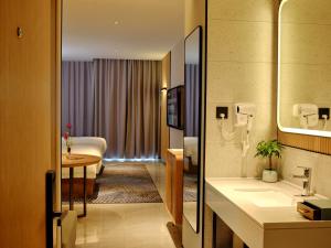baño con lavabo y 1 cama en una habitación en CitiGo HOTEL - 越南平阳新渊欢阁酒店 