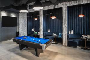 a room with a pool table and couches at Aloft Fort Lauderdale Airport in Fort Lauderdale