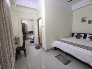 1 dormitorio con cama, escritorio y espejo en THE STAY CORNER, en Guwahati