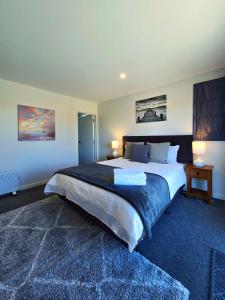 a bedroom with a large bed with two lamps on it at Kingfisher Lodge in Lake Tekapo