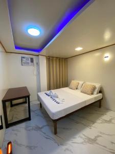 a room with a bed and a table in it at Isla Amakan Homestay North Siargao in Alegria