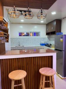 a kitchen with two wooden stools at a counter at Isla Amakan Homestay North Siargao in Alegria