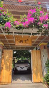 une voiture est garée dans un garage avec des fleurs roses dans l'établissement NT House, à Đà Nẵng