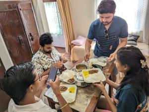a group of people sitting around a table eating food at HILL TOP HOMES in Kannur