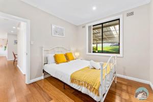 Habitación blanca con cama y ventana en Aircabin - Beacon Hill - Lovely - 3 Beds House, en Oxford Falls