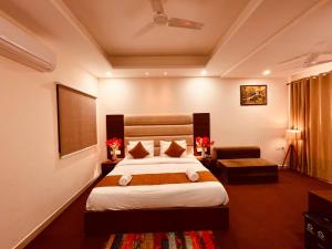 a hotel room with a bed and a chair at Raga Resort, Haridwar in Haridwār
