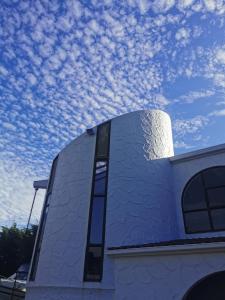 un edificio bianco con un cielo sullo sfondo di Luxury Harbour view a Dunedin
