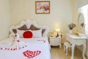 a white bedroom with a bed with red hearts on it at Happy Star Hotel Nha Trang in Nha Trang