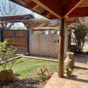 a patio with a wooden pergola and a vase at comodidad y tranquilidad in Jesús María