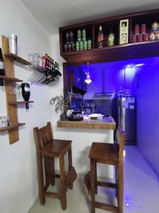 una cocina con 2 sillas y un bar con iluminación púrpura en Homelux Transient House en Ciudad de Cauayán