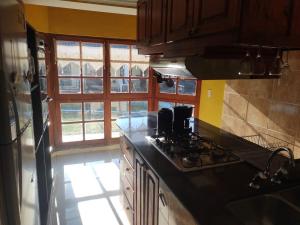 a kitchen with a stove top oven next to a window at comodidad y tranquilidad in Jesús María