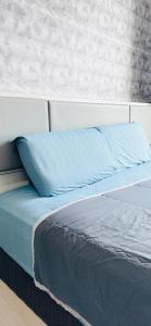 a bed with a blue pillow on top of it at H20 Residence Ara Damansara Petaling Jaya in Petaling Jaya