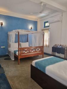 a bedroom with two beds and a canopy bed at Darshana Beach Hotel in Kosgoda