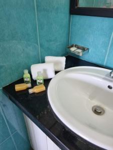 a bathroom sink with two bottles of soap on a counter at Darshana Beach Hotel in Kosgoda