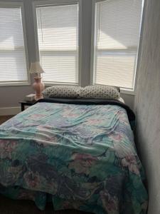 - une chambre avec un lit et une couette colorée dans l'établissement Shared 4 Bedroom House, à South Bend