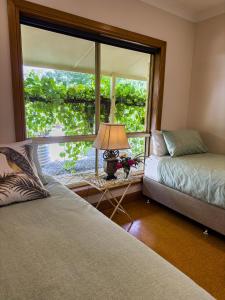 a bedroom with two beds and a large window at Barossa Garden Homestay in Williamstown