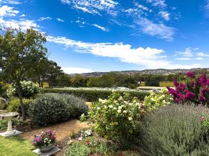 a garden with flowers and bushes on a sunny day at Barossa Garden Homestay in Williamstown