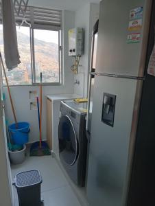 a kitchen with a refrigerator and a washing machine at Apartamento en Edificio Puerto paraiso en Bello Antioquia in Bello