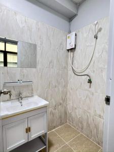 La salle de bains est pourvue d'un lavabo et d'une douche. dans l'établissement Luna hotel สถานีดอนเมือง, à Ban Don Muang (1)