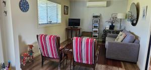 a living room with two chairs and a couch at The Wattle Lodge in Glendon Brook