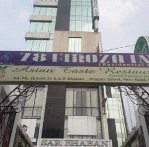 a sign in front of a tall building at 78 Firoza Inn in Dhaka