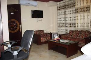 a hotel room with a desk and a couch and a table at 78 Firoza Inn in Dhaka