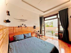 a bedroom with a bed and a large window at Mon's House in Da Lat