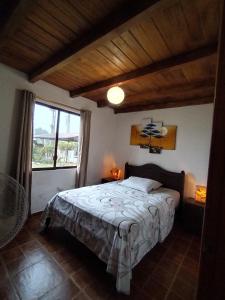 sypialnia z łóżkiem i dużym oknem w obiekcie Quinta Nairobi w mieście Pedro Vicente Maldonado