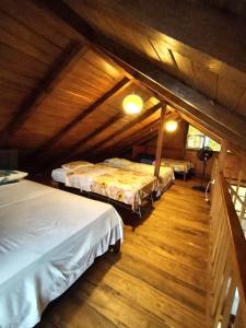 2 łóżka w pokoju z drewnianą podłogą w obiekcie Quinta Nairobi w mieście Pedro Vicente Maldonado