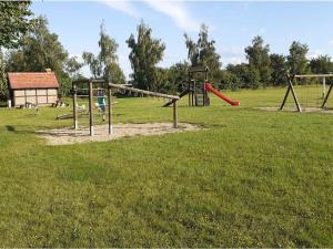 an empty playground with two swings in a field at "Lake view" Modern retreat in Torgelow am See