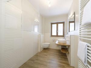 biała łazienka z toaletą i umywalką w obiekcie Schachen Modern retreat w Garmisch Partenkirchen