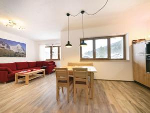 salon z czerwoną kanapą i stołem w obiekcie Schachen Modern retreat w Garmisch Partenkirchen