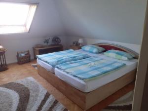 1 dormitorio con cama con sábanas azules y ventana en "Lake view" Modern retreat, en Torgelow am See