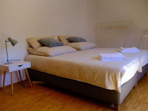 uma cama grande num quarto com um candeeiro sobre uma mesa em Dream vacation on Lake Ammersee em Schondorf am Ammersee