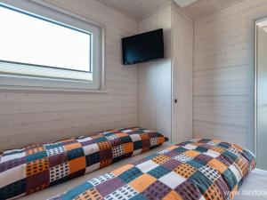 two beds in a room with a tv on the wall at Houseboat Harmony in Stralsund