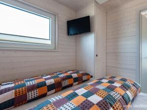 twee bedden in een kamer met een tv aan de muur bij Houseboat Harmony in Stralsund