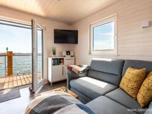 een woonkamer met een bank en een tv bij Houseboat Harmony in Stralsund