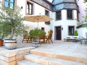 a patio with chairs and an umbrella in front of a house at Halfenschänke Modern retreat in Piesport