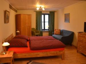 a bedroom with a red bed and a blue couch at Halfenschänke Modern retreat in Piesport