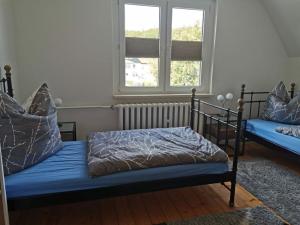 una camera con due letti con lenzuola blu e una finestra di Haus Waldliebe Modern retreat a Hüttenrode