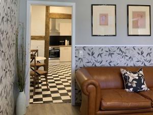 a living room with a couch and a kitchen at CATHEDRAL WHISPERS Modern retreat in Schwerin