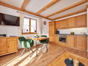 eine Küche mit Holzschränken sowie einem Tisch und Stühlen in der Unterkunft Holiday apartment "Wetterstein" in Krün
