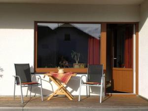 a patio with a table and chairs and a glass door at Kläs Haus Eifelsonne 