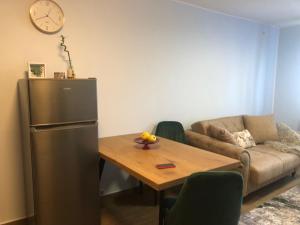 a kitchen with a refrigerator and a table and a couch at Joy in Oradea