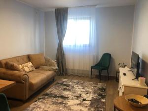 sala de estar con sofá y ventana en Joy en Oradea