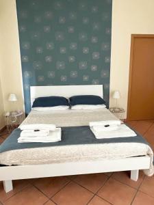 ein Schlafzimmer mit einem Bett mit zwei Handtüchern darauf in der Unterkunft Wanderlust Guesthouse in Lamezia Terme