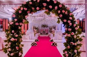 un altar de bodas con flores rosas y una alfombra roja en A&A Plaza Hotel, en Puerto Princesa City