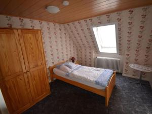 - une petite chambre avec un lit et une fenêtre dans l'établissement Ferienhof Junge Modern retreat, à Wingst