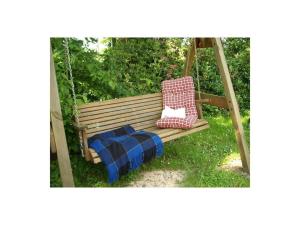- une balançoire en bois avec un oreiller et une couverture dans l'établissement Ferienhof Junge Modern retreat, à Wingst
