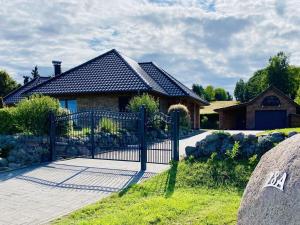 a house with a gate in front of a house at Rügen Apartment Waterview in Buschvitz